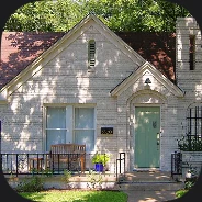 A painted brick cottage with a steep gabled roof