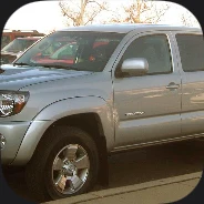 A silver double-cab pickup in a parking lot